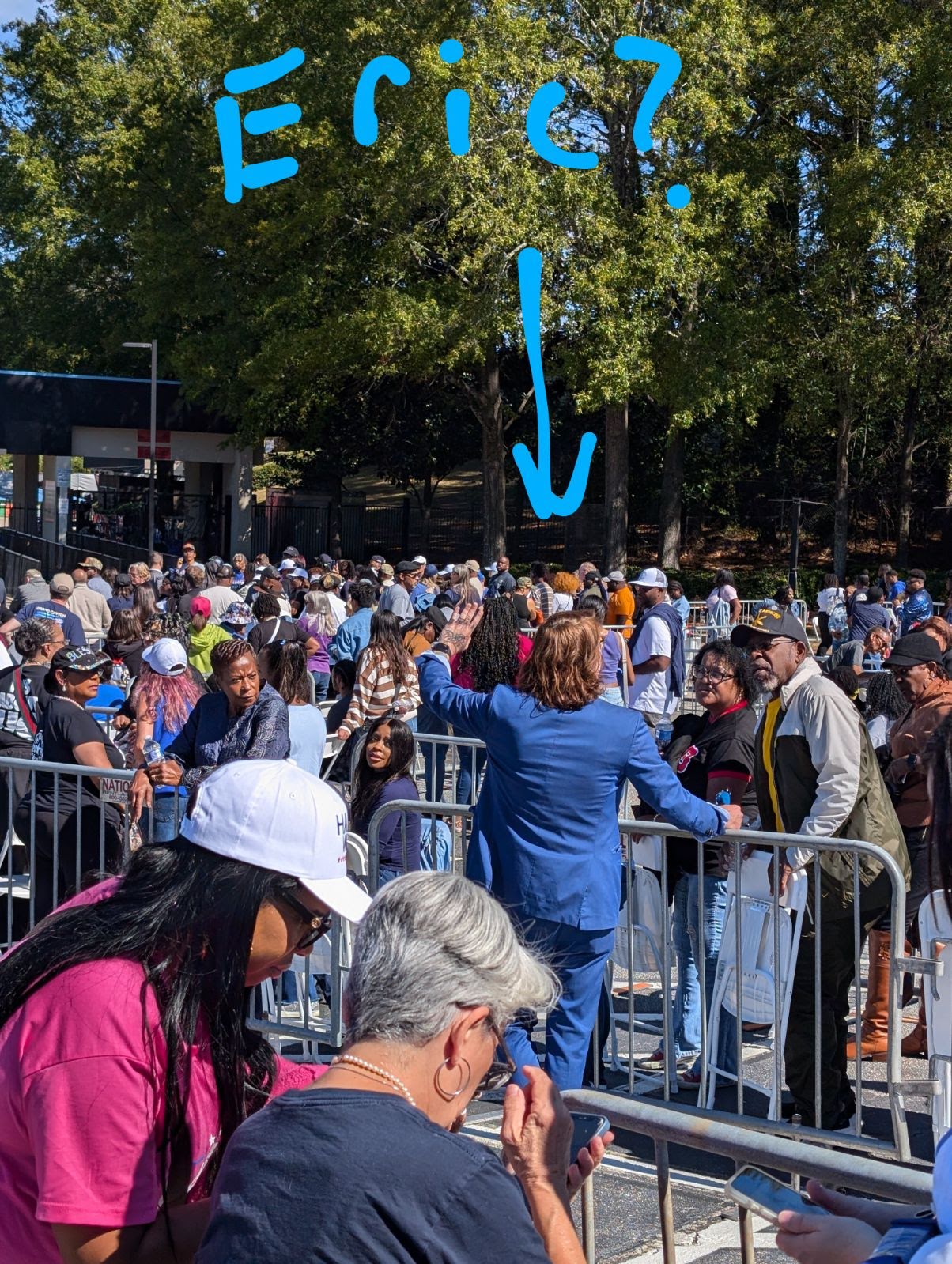 person in blue suit in a crowd with text written in blue saying 'Eric?'